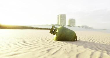 CGI Green object rests on sandy beach near buildings during sunset video