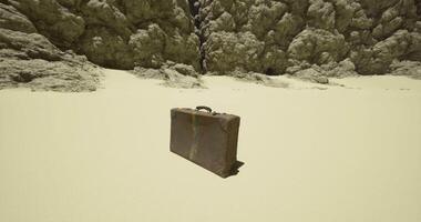CGI Abandoned suitcase resting on a sandy surface near rocky cliffs video