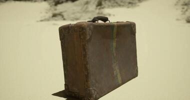 CGI Old leather suitcase resting on a sandy surface in an isolated area video