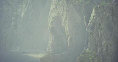 CGI Coastal cliffs shrouded in mist with waves gently lapping the shore video