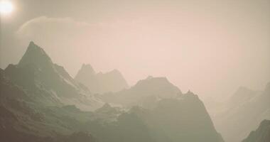 CGI Snow capped mountains rise under soft sunlight in a serene landscape video