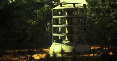 CGI Unique structure stands alone in a remote area surrounded by trees at sunset video