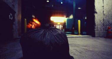 CGI Garbage bag left in alley at night near lighted loading dock video