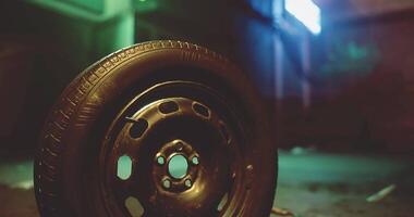 CGI Close up of a black tire resting on a dimly lit urban street at night video