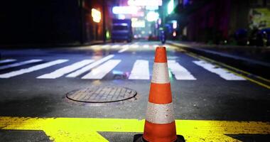 CGI Traffic cone positioned on a wet street illuminated by neon lights at night video