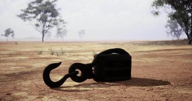 CGI Rusty hook rests on cracked earth under a cloudy sky at a remote location video