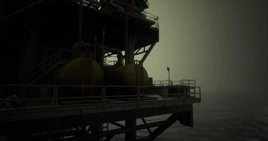 CGI Oil rig operations at dusk over the ocean in dark and moody atmosphere video
