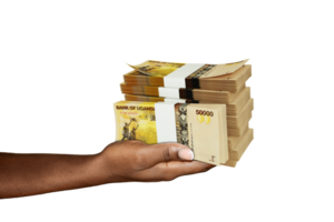 Hand Holding 3D rendering of stacks of Ugandan shilling notes isolated on transparent background png
