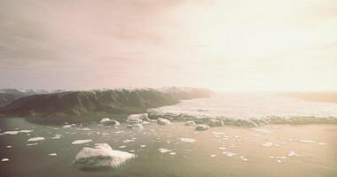 CGI Icebergs float in the tranquil waters of a remote glacier bay at sunset video