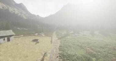 CGI Scenic mountain landscape with mist and rustic buildings at dawn video