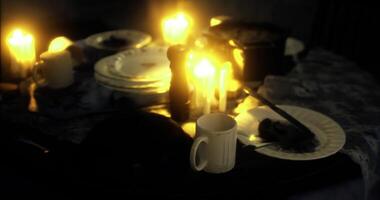 CGI Soft candlelight fills the room, casting a warm glow on a disheveled table video