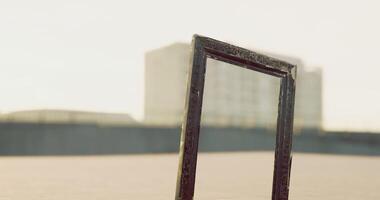 CGI Unique empty picture frame placed outdoors with distant buildings in background video
