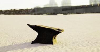 CGI Anvil resting on sandy shore near modern buildings in bright daylight video