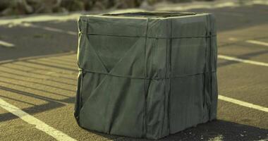 CGI Unique green crate on an empty parking lot under bright sunlight video
