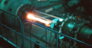 CGI Industrial machinery produces bright flame in a dark workshop setting video