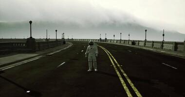 CGI Astronaut standing alone on a deserted road in a foggy landscape video