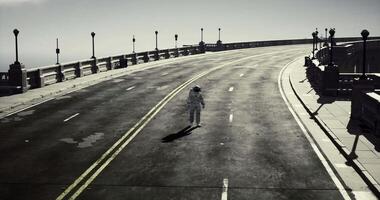 CGI Astronaut walking alone on an empty road alongside the ocean in daylight video