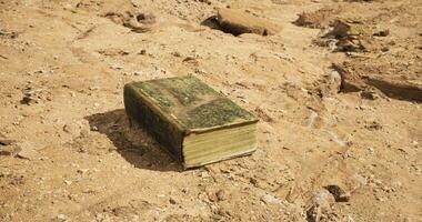CGI Old book resting on dusty ground in a deserted area under bright sunlight video