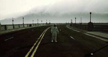 CGI Astronaut standing alone on an empty road with fog covered mountains video