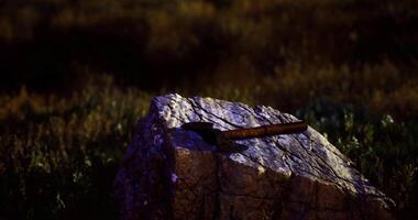 CGI Rusty hammer resting on a stone at night in a natural setting video