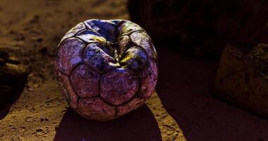 CGI Old soccer ball resting on the ground in an arid environment at dusk video