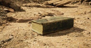 CGI Ancient book lying on sandy terrain under natural sunlight in desert video
