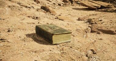CGI Ancient book resting on dry ground in a remote desert setting video