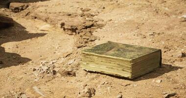 CGI Ancient book resting on sandy ground in archaeological site video