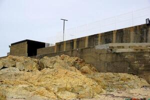 Coastal concrete structure and rock formations at the beach landscape scenery photo