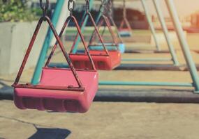 Empty children swing set in playground photo