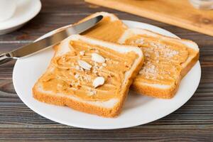 Peanut butter sandwiches toasts on light table background.Breakfast. Vegetarian food. photo