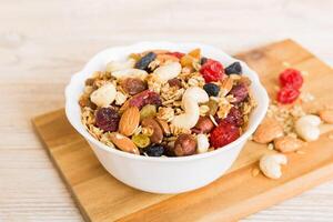 Cooking wholesome breakfast. Granola with Various dried fruits and nuts in a bowl. The concept of healthy dessert photo