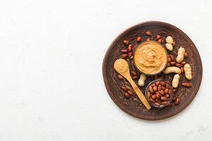 Bowl of peanut butter and peanuts on table background. top view . Creamy peanut pasta photo