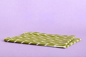 top view green kitchen napkin isolated on table background. Folded cloth for mockup with copy space photo