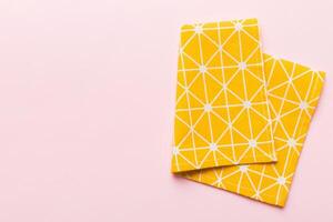 top view with yellow empty kitchen napkin isolated on table background. Folded cloth with copy space photo