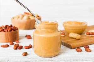 Bowl of peanut butter and peanuts on table . top view with copy space. Creamy peanut pasta photo