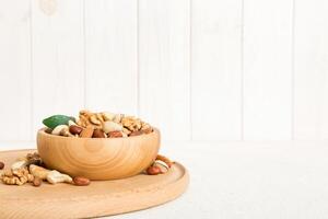 mixed nuts in bowl. Mix various nuts on colored background. pistachios, cashews, walnuts, peanuts photo