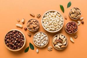 mixed nuts wooden bowl. Mix various nuts on colored background. pistachios, cashews, walnuts, hazelnuts, peanuts photo