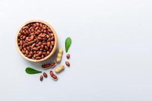 healthy peanuts in bowl on colored table background. Top view Healthy eating bertholletia concept. photo