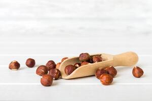 Hazelnut heap in spoon wooden table, top view photo