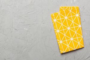 yellow empty kitchen napkin isolated on table background. Folded cloth for mockup with copy space. Minimal style photo