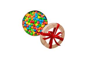 Set of different sweet candy in a paper box with a satin ribbon on a colored background photo