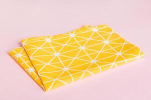 top view yellow empty kitchen napkin isolated on table background. Folded cloth for mockup photo