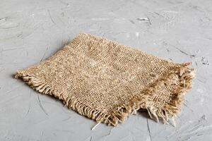 Old burlap fabric napkin, sackcloth on table background. photo