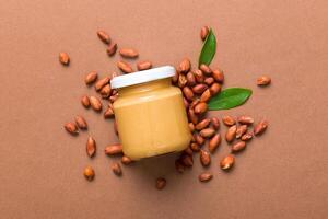 Bowl of peanut butter and peanuts on table . top view with copy space. Creamy peanut pasta in small bowl photo