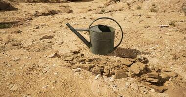 CGI Empty watering can stands alone on dry cracked earth under harsh sun video