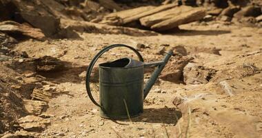 CGI Watering can on dry soil in an arid landscape during daylight hours video