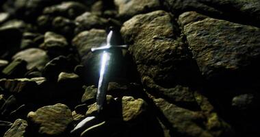CGI Sword resting on rocky terrain under dim light at night video