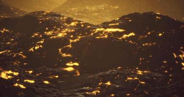 CGI Molten lava flows illuminate the rocky landscape during twilight hours video