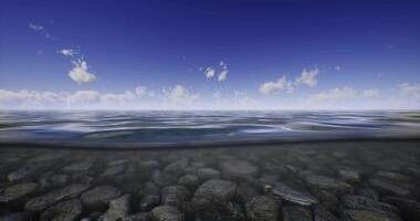 CGI Beneath the surface of clear water revealing pebbles and sky reflections video